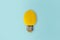 Lemon light bulb on bright blue background. Summer fun concept.