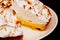 Lemon Meringue Pie on White Plate homemade Cake dessert. Wooden Background. close Up.