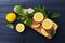 Lemon and mint leaves served on wooden kitchen board on black rustic table, ingredient for summer cocktails and lemonade