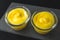 Lemon pudding or lemon curd close up in glass bowls on black background