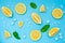 Lemon set with ice cubes and mint leaves on blue background.