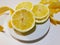 Lemon and sliced lemon rind on a plate on white table large