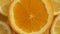 Lemon slices with one cut orange slice closeup, summer background, top view. Rotation