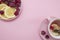 Lemon slices and raspberries in a pink plate on a pink background. Flat lay of tropical summer. Nutrition concept.