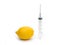 Lemon and syringe on a white background close-up, genetically modified organism. GMO. Vitamins.