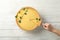 Lemon tart and person holding spatula with slice on background, top view