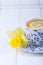 Lemon tea and yellow daffodil on a white background. Free space