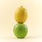 Lemon on top of the green apple isolated on yellow background waiting for the perfect recipe