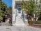 A lemon tree in a yard and marble stairs to a vintage house entrance with a white door.