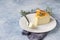 Lemon vanilla cheesecake decorated with rosemary, mint and lemon slices. Ricotta no crust cheesecake or casserole. Blue background