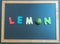 Lemon wooden word on black board
