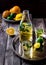 Lemonade in bottle and two glasses on vintage metal tray. Wooden background.