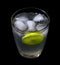 Lemonade with ice in crystal glass on black background