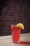 lemonade on table, mint and lemon wedge, glass with straw, brick wall on background, close-up, macro