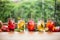 Lemonades on summer spring terrace table with organic fruits on leaf bokeh