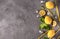 Lemons,  Basil sprigs, ice cubes, yellow and blue tubes on a gray background  top view