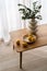 Lemons in bowl close to vase with eucalyptus plants on table