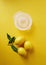 Lemons with lemon squeezer against a yellow background