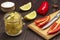 Lemons with salt in jars and chili pepper on cutting board