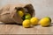 Lemons studio image. Bag of lemons and lime. Fabric bag with lemons. Full sack of lemons