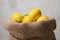 Lemons studio image. Bag of lemons and lime. Fabric bag with lemons. Full sack of lemons