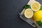 The lemons are on top of wood cutting board with knife. Top view with copy space, flat lay