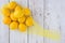 Lemons in a yellow mesh bag on a whitewashed wood background