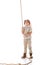 Length view of smiling explorer kid in hat and glasses holding rope on white