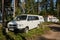 Leningrad Region, Russia - June 2022. Volkswagen transporter T4 minivan is white in front, and Dodge with trailer in