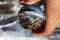 Through lens ball watchs rough sea, tides and foamed water as it smashes against the rocks. Piece of famous beach Baths Of