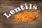 Lens culinaris - Uncooked orange lentils on rustic wooden background
