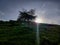 Lens flare seen through clouds in a open forest area