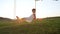 LENSE FLARE: Happy young girl relaxing on a wooden swing smiling at the camera