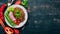 Lentil with radish, cherry tomatoes, beans and vegetables. Healthy food. On a black wooden table.