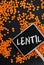 Lentils on black background and chalkboard with word lentil