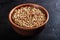 Lentils in a clay vessel on a black concrete background