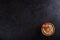 Lentils in a clay vessel and a wooden spoon with place for text on a black concrete background