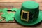 Leprechaun hat and decorative clover leaves on wooden table, closeup. St Patrick`s Day celebration