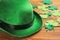 Leprechaun`s hat and decorative clover leaves on wooden background, closeup. St. Patrick`s day celebration