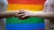 Lesbian couple holding hands, rainbow flag on background, minority rights, lgbt