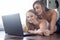 Lesbian domestic couple on floor at laptop online communication