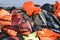 LESVOS, GREECE OCTOBER 24, 2015: Lifejackets, rubber rings an pieces of the rubber dinghys discarded on a beach near Molyvos.