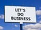 let is do business symbol. Concept words let is do business on beautiful big white billboard. Beautiful blue sky cloud background