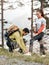 Let me help you there. Full length shot of a handsome young man tying his friends shoelaces while on a hike in the woods