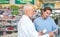 Let me just double-check. a handsome mature male pharmacist helping a customer in the pharmacy.