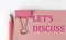 LET`S DISCUSS word on pink paper with pink pencil