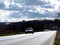 Let`s drive! Asphalt road in perspective with car, church & blue sky