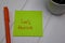 Let`s Thrive write on sticky note isolated on wooden table