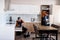 Let us work. Full length shot of two handymen, workers in uniform assembling kitchen cupboard, cabinet using screwdriver