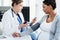 Lets check your blood pressure. a confident female doctor checking the blood pressure of a pregnant patient at a